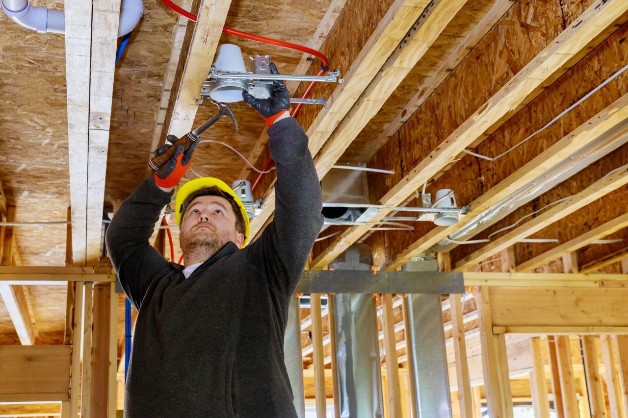 the-electrician-nailing-to-the-ceiling-lamp-installs-the-lighting-lamp